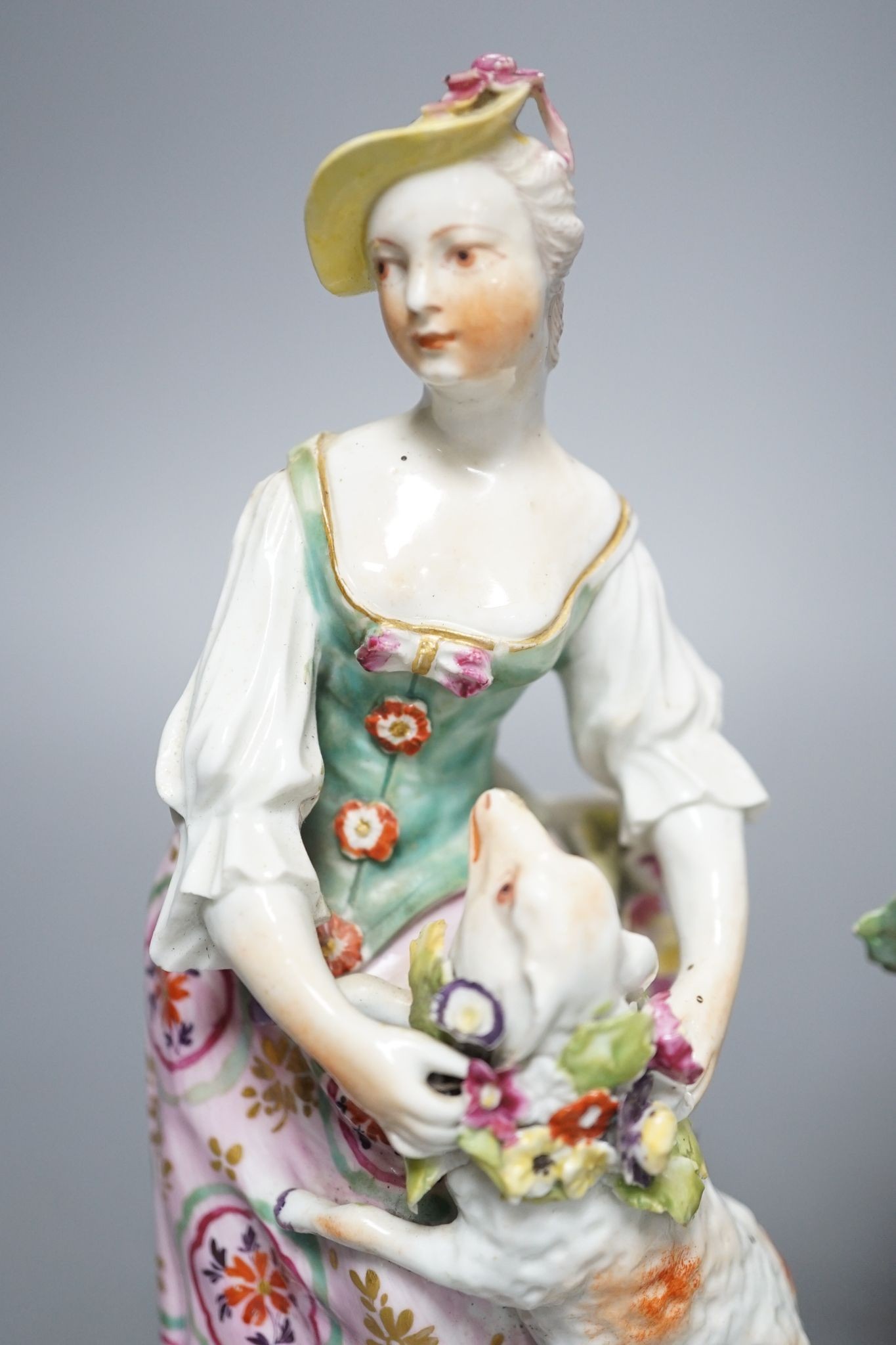 Two Derby porcelain figures of a gentleman holding a bird’s nest and a lady with a sheep, c.1760, 21.5 cms high.